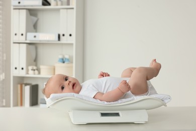 Cute little baby lying on scales in clinic