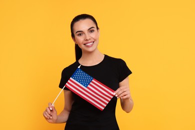 Photo of 4th of July - Independence Day of USA. Happy woman with American flag on yellow background