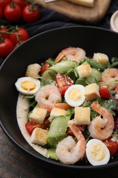 Photo of Delicious Caesar salad with shrimps on table, closeup