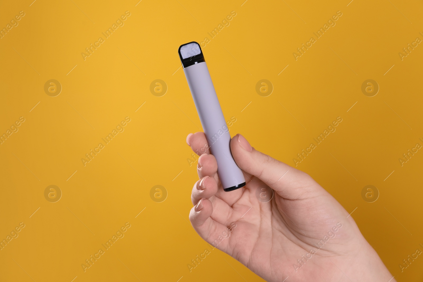 Photo of Woman holding electronic cigarette on orange background, closeup