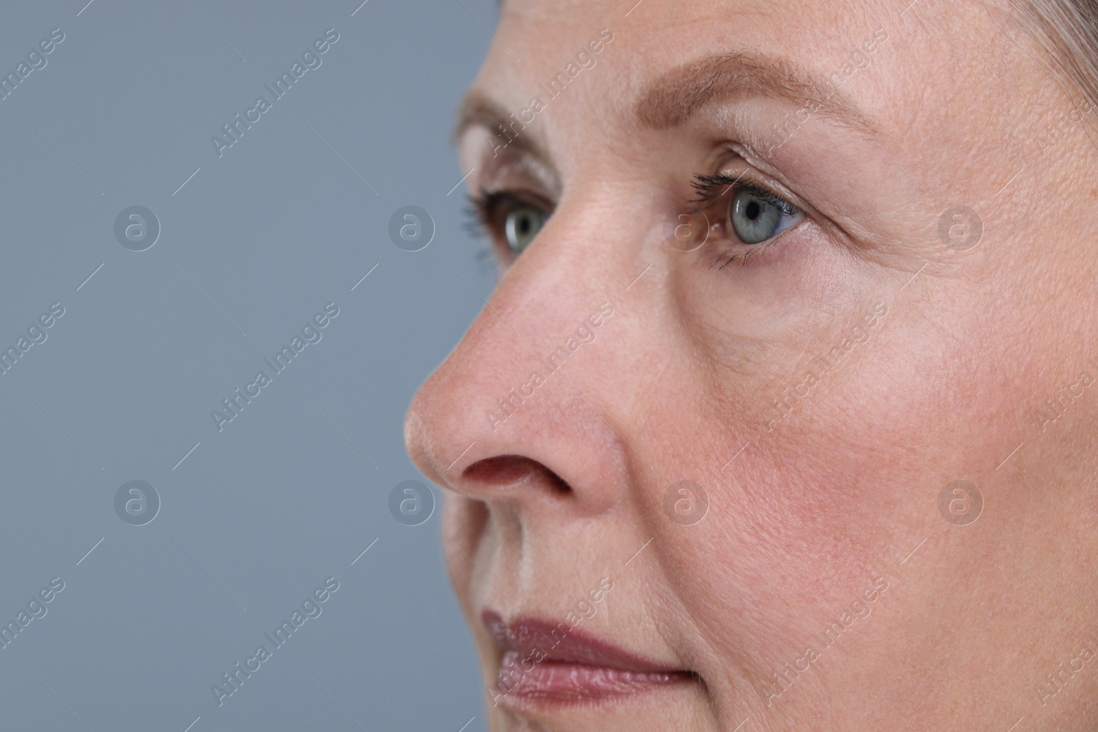 Photo of Senior woman with aging skin on grey background, closeup and space for text. Rejuvenation treatment