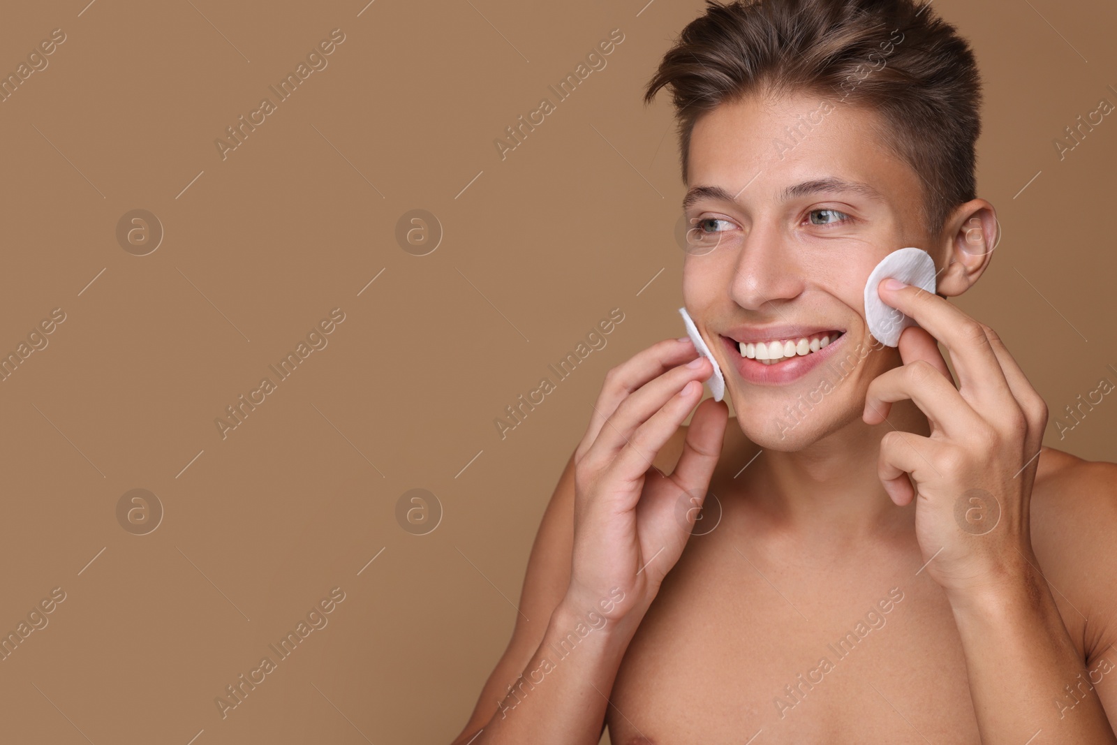 Photo of Handsome man with cotton pads on beige background, space for text