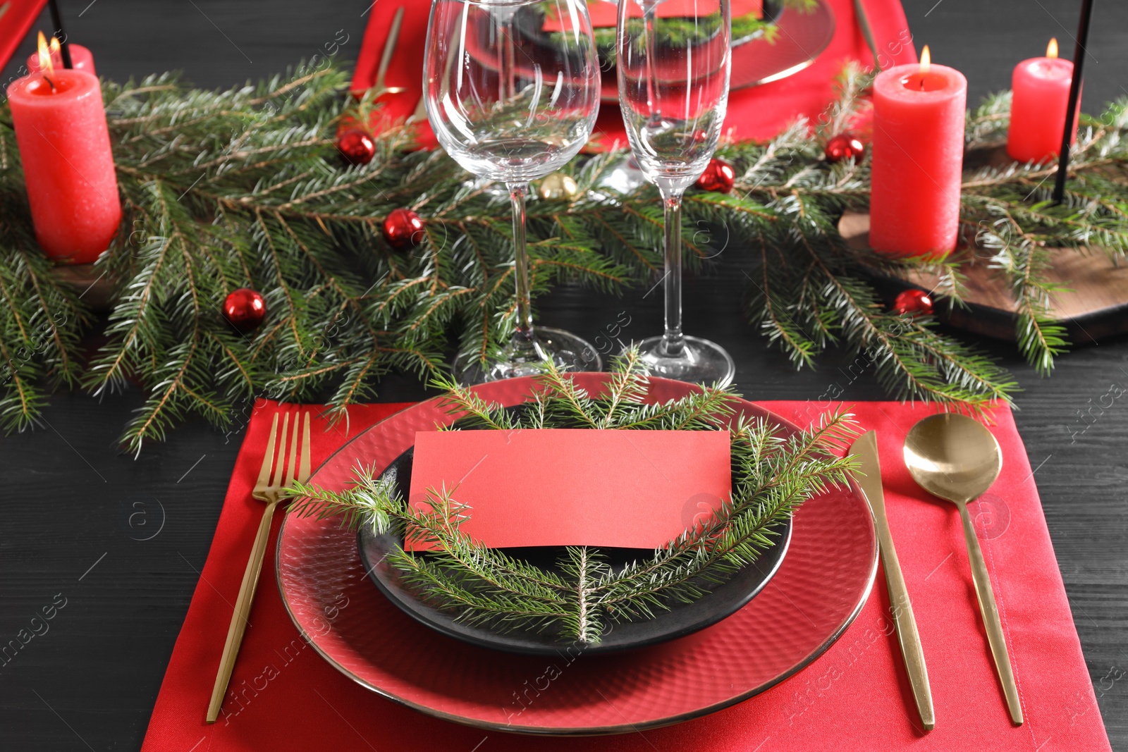 Photo of Elegant Christmas place setting with blank card and festive decor on table