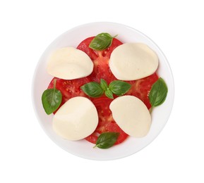 Photo of Plate of delicious Caprese salad with tomatoes, mozzarella and basil isolated on white, top view