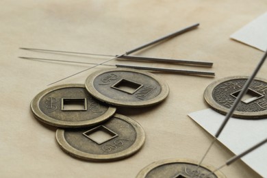 Acupuncture needles and ancient coins on paper, closeup