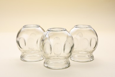 Photo of Glass cups on beige background. Cupping therapy