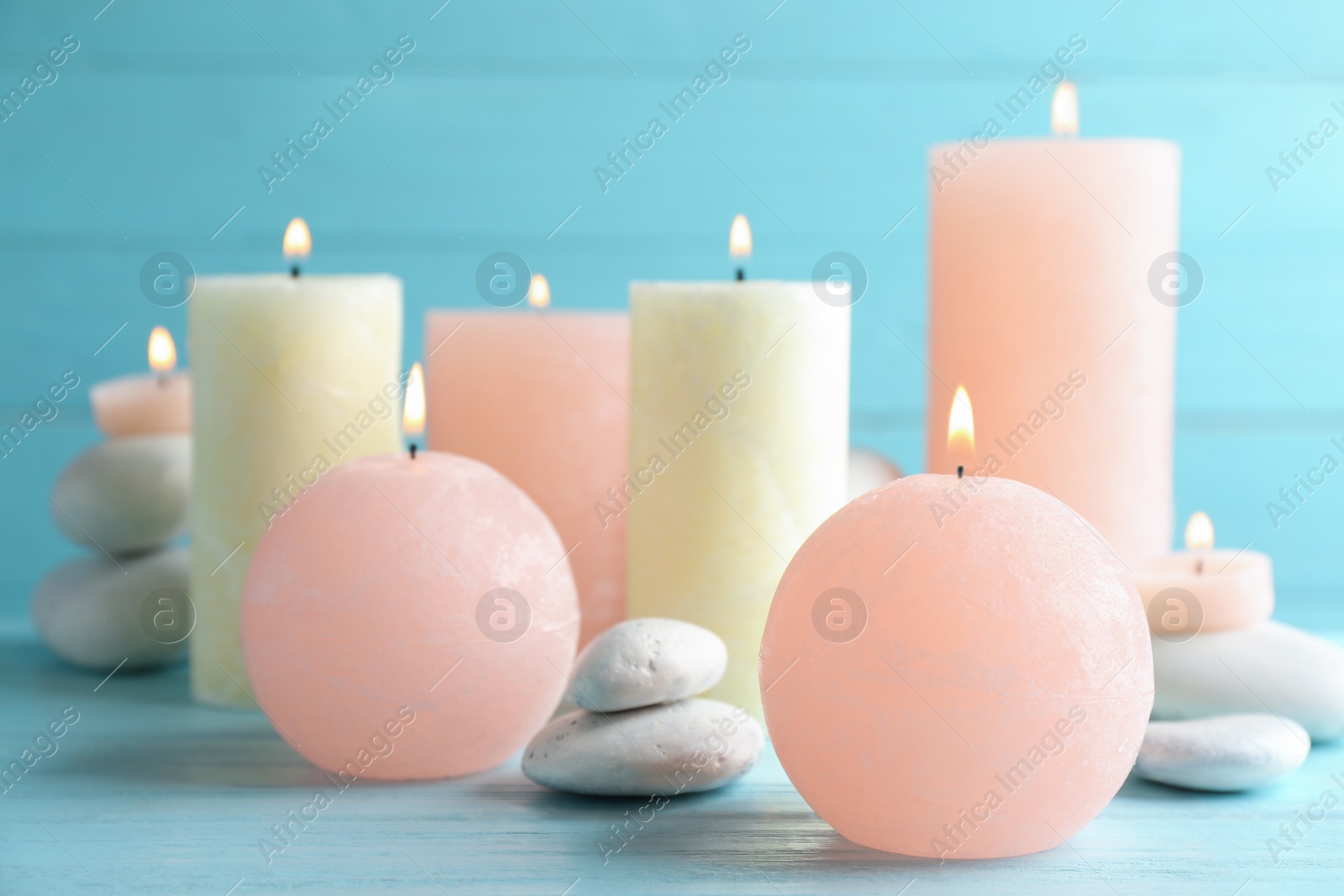 Photo of Burning candles and spa stones on table. Space for text