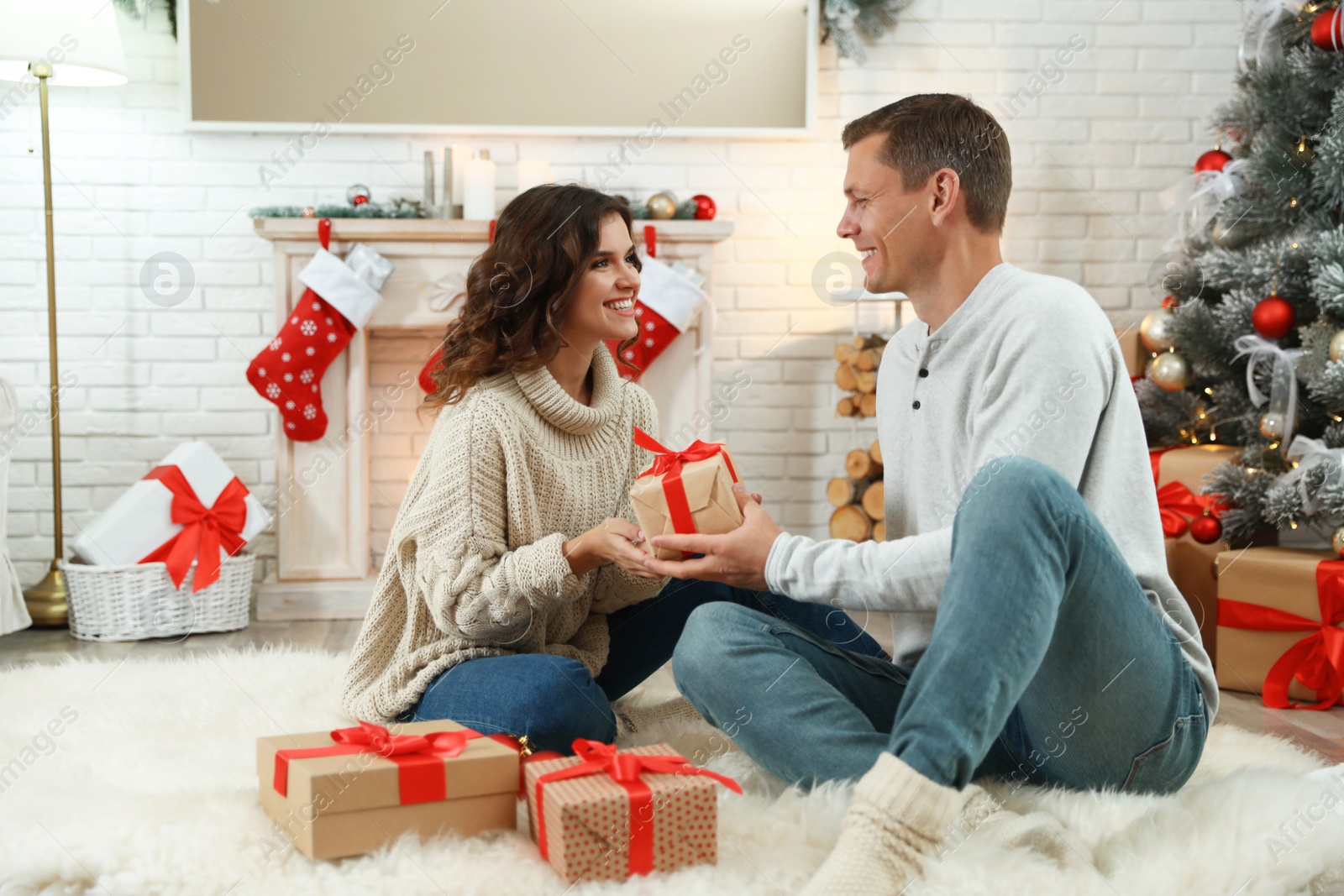 Image of Happy couple with Christmas gift at home
