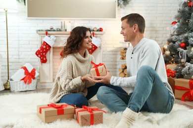 Image of Happy couple with Christmas gift at home