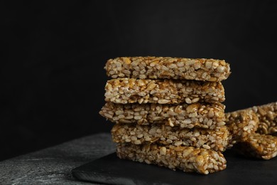 Delicious sweet kozinaki bars on grey table against dark background