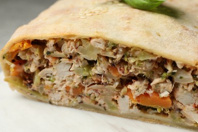 Photo of Delicious strudel with chicken and vegetables on light table, closeup