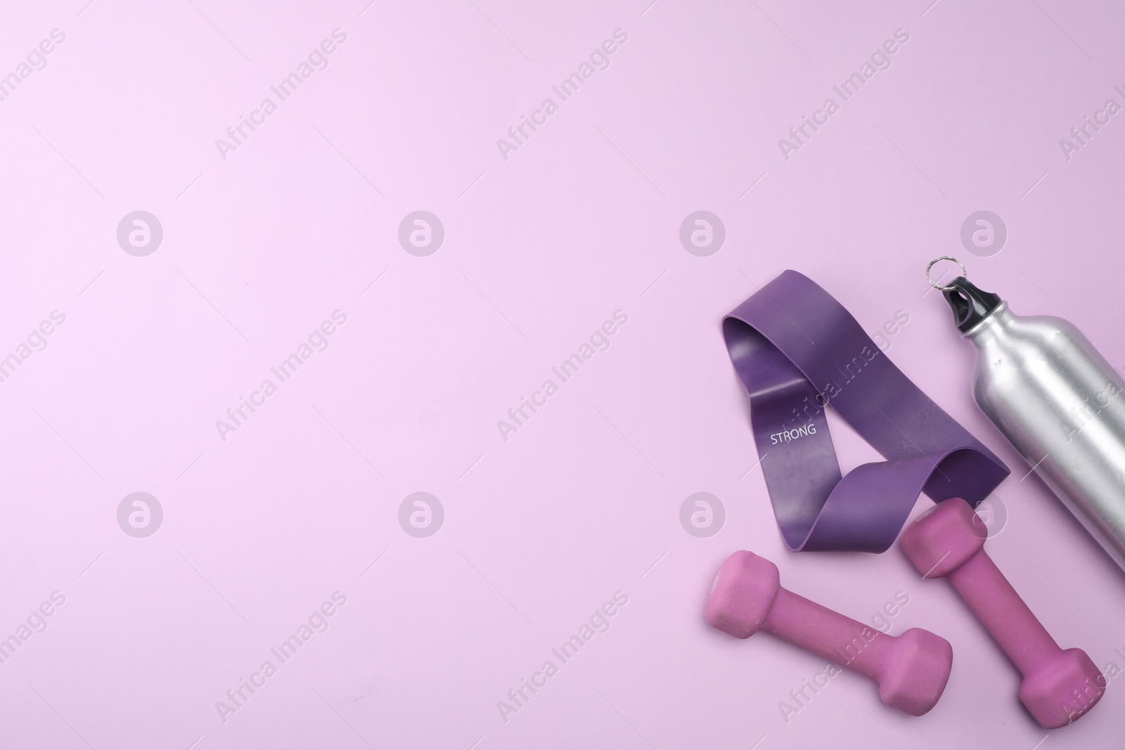 Photo of Two dumbbells, fitness elastic band and thermo bottle on violet background, flat lay. Space for text