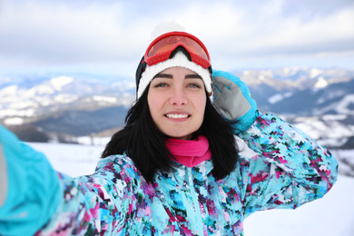 Young woman taking selfie at mountain resort. Winter vacation