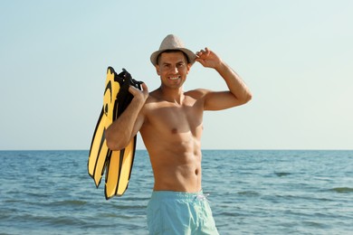 Photo of Happy man with flippers near sea on beach