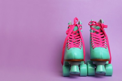 Photo of Pair of stylish quad roller skates on color background. Space for text