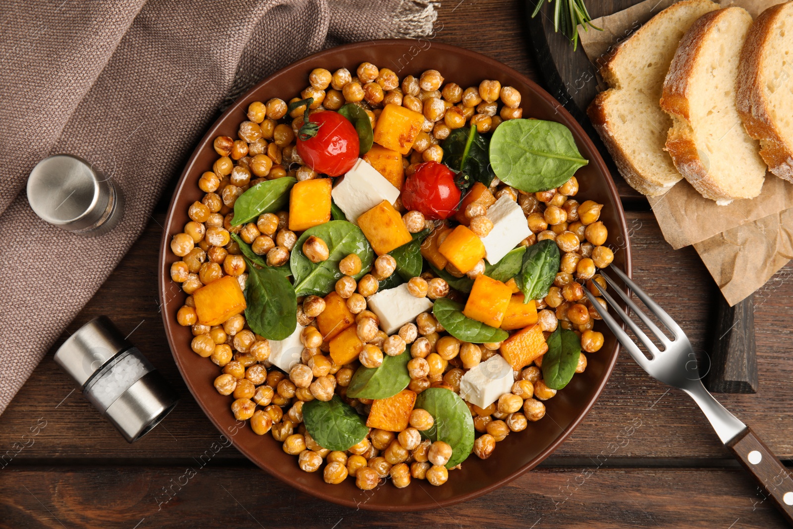 Photo of Delicious fresh chickpea salad served on wooden table, flat lay