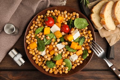 Delicious fresh chickpea salad served on wooden table, flat lay