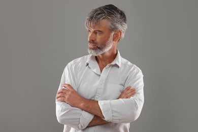 Portrait of confident man with beautiful hairstyle on light grey background