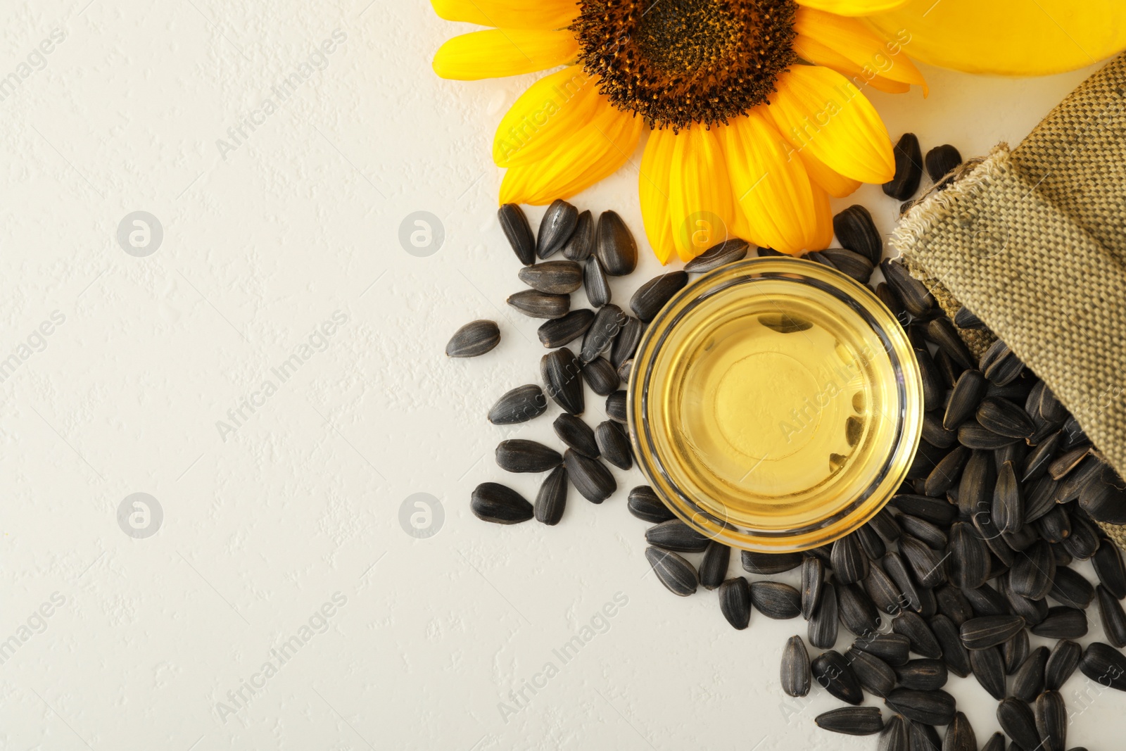 Photo of Flat lay composition with sunflower oil on white table, space for text