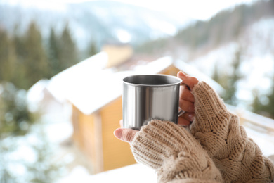 Woman with cup of tasty coffee outdoors on winter morning, closeup