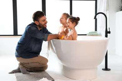 Young father with little daughters in bathroom