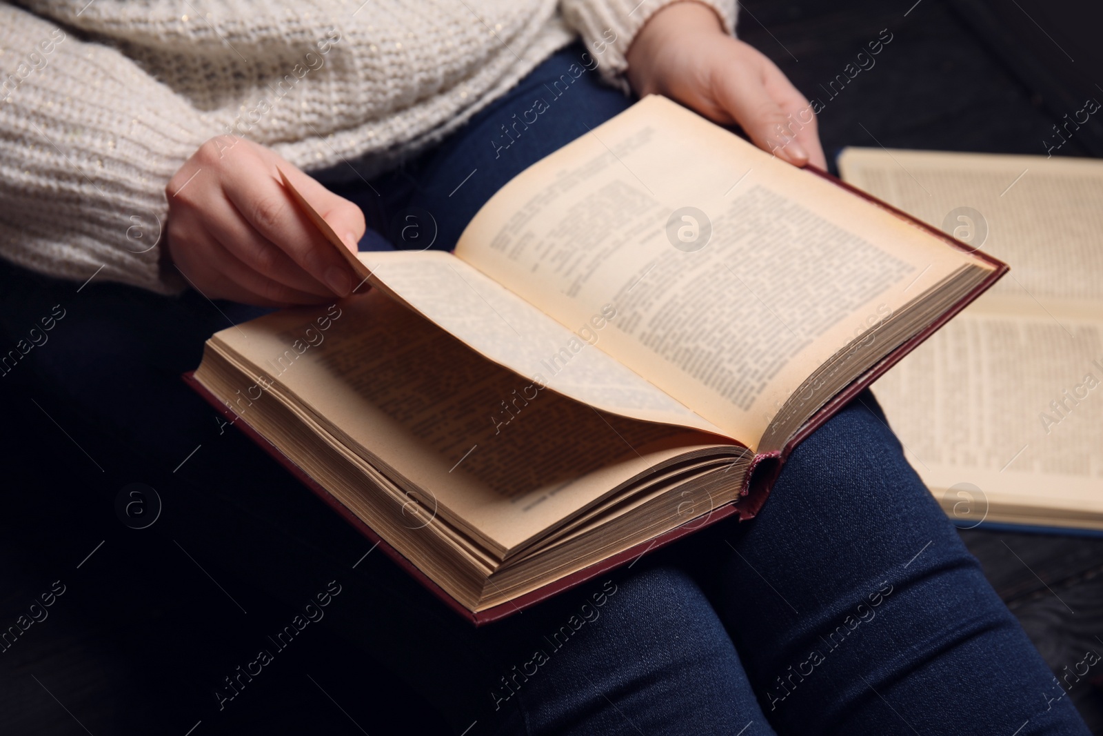 Photo of Young woman reading book at home, closeup