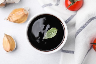 Organic balsamic vinegar and cooking ingredients on white table, flat lay