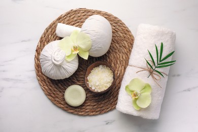 Flat lay composition with spa products and beautiful flowers on white marble table