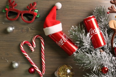 MYKOLAIV, UKRAINE - January 01, 2021: Flat lay composition with Coca-Cola cans and Christmas decorations on wooden background