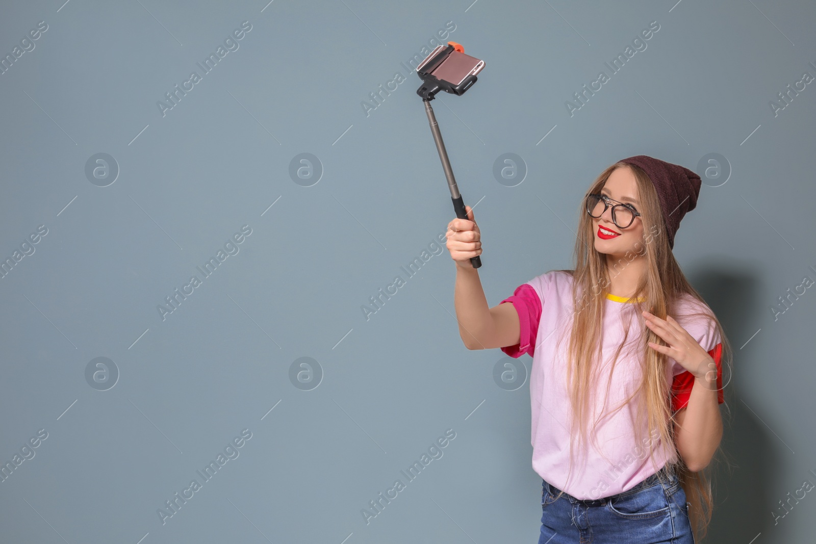 Photo of Attractive young woman taking selfie on grey background