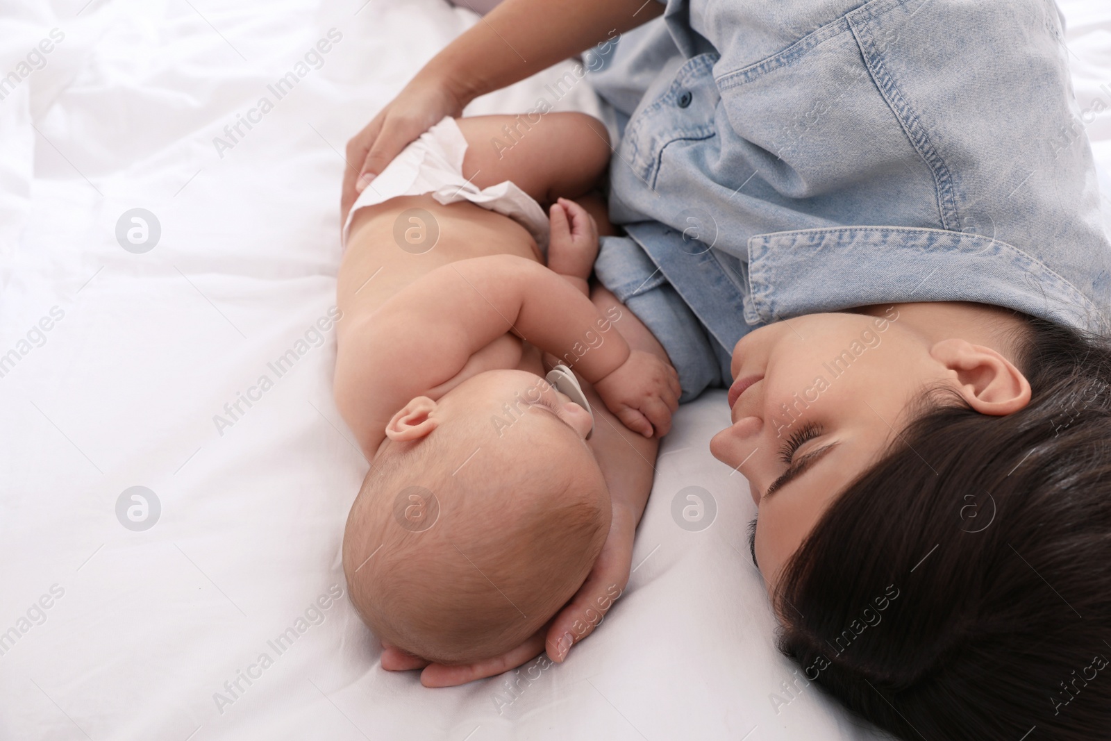 Photo of Mother with her cute baby sleeping on bed