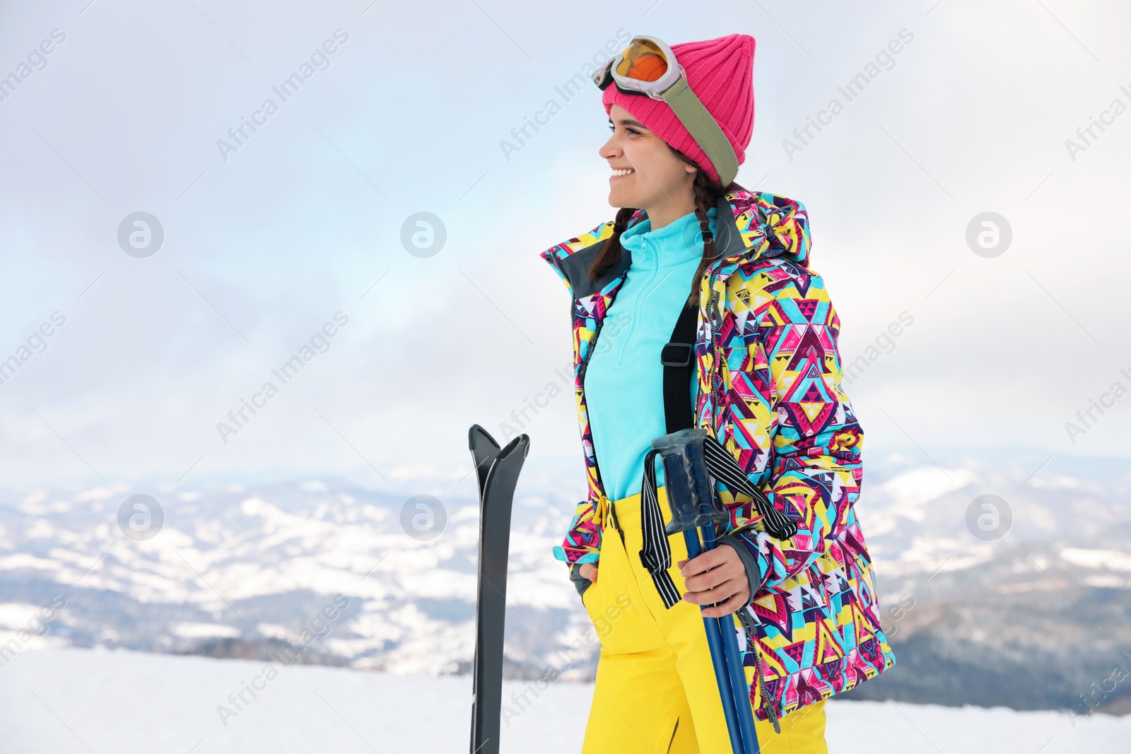 Photo of Young woman with ski on snowy hill. Winter vacation