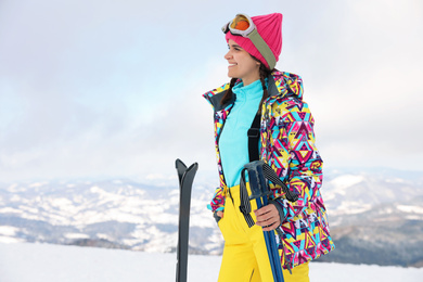 Photo of Young woman with ski on snowy hill. Winter vacation