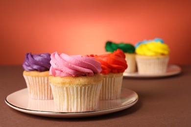 Delicious cupcakes with bright cream on color background