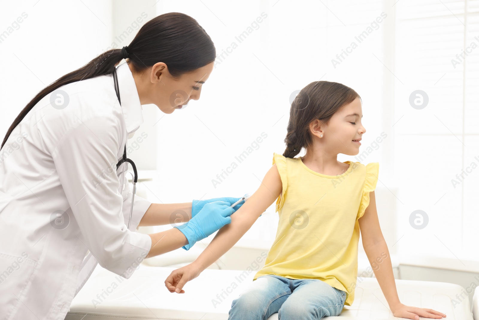 Photo of Doctor vaccinating little child in modern clinic