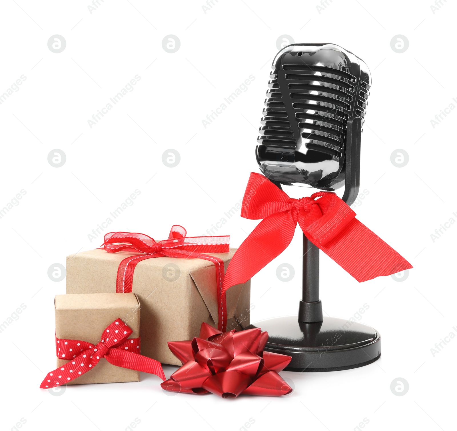 Photo of Retro microphone with red bow and gift boxes on white background. Christmas music