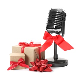 Photo of Retro microphone with red bow and gift boxes on white background. Christmas music