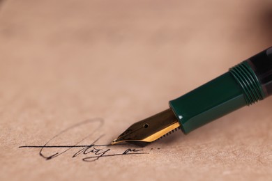 Photo of Signing on sheet of paper with fountain pen, closeup. Space for text