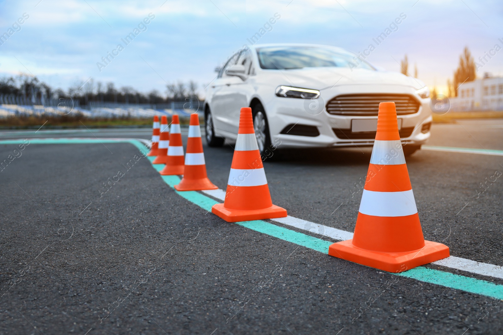 Photo of Modern car at test track, focus on traffic cone. Driving school