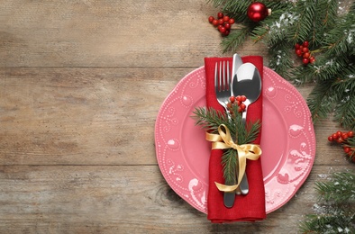 Christmas table setting on wooden background, flat lay. Space for text