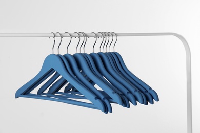 Metal rack with clothes hangers on white background