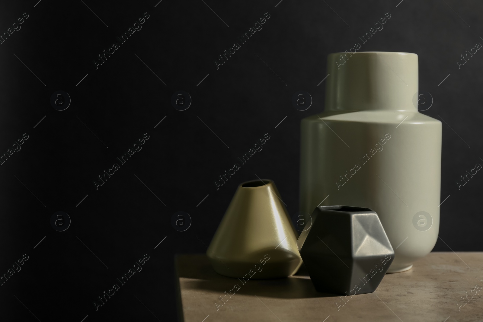Photo of Stylish empty ceramic vase on table against black background, space for text