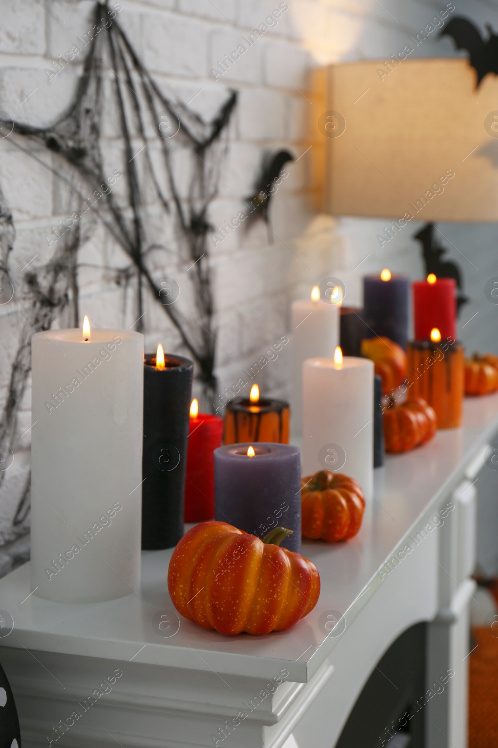 Photo of Fireplace with different Halloween decor indoors. Festive interior