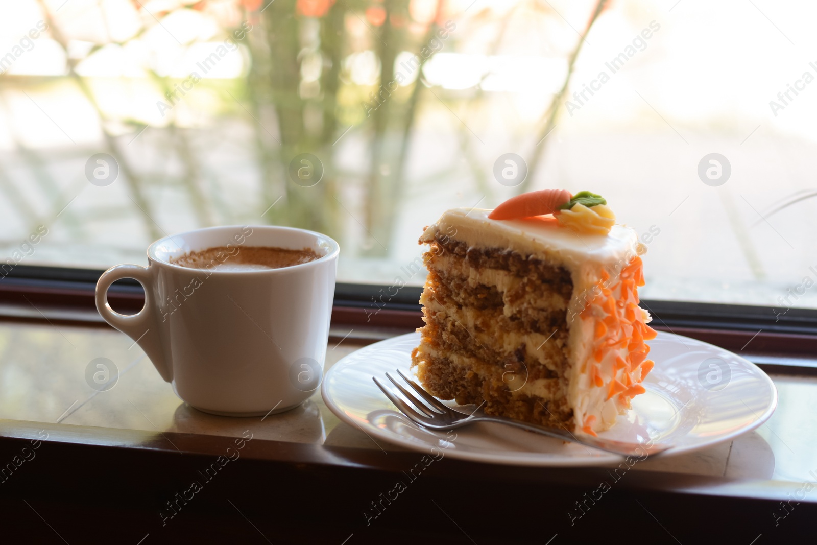 Photo of Delicious cake and cup of hot coffee on windowsill indoors