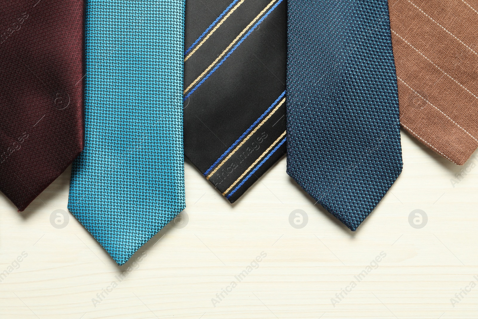 Photo of Different neckties on white wooden table, flat lay