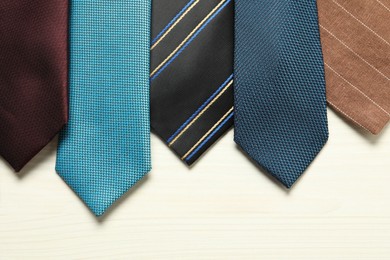 Photo of Different neckties on white wooden table, flat lay