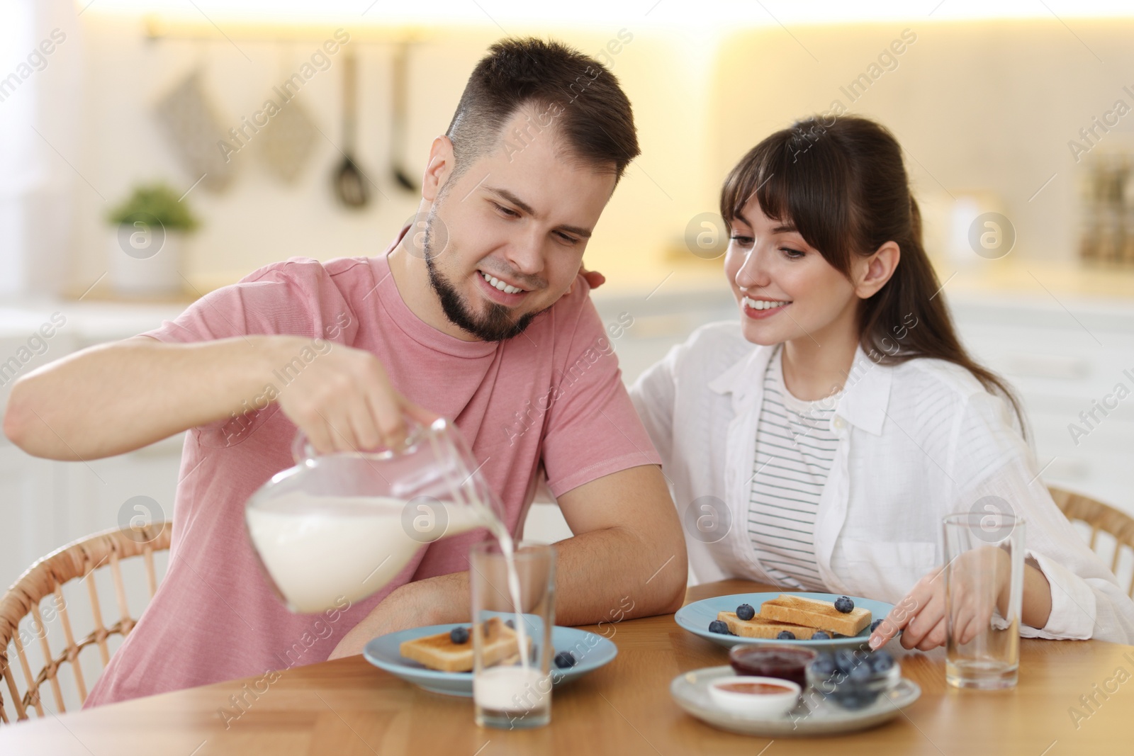 Photo of Happy couple having tasty breakfast at home