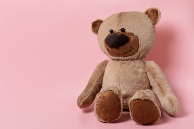 Photo of Cute teddy bear on pink background, space for text