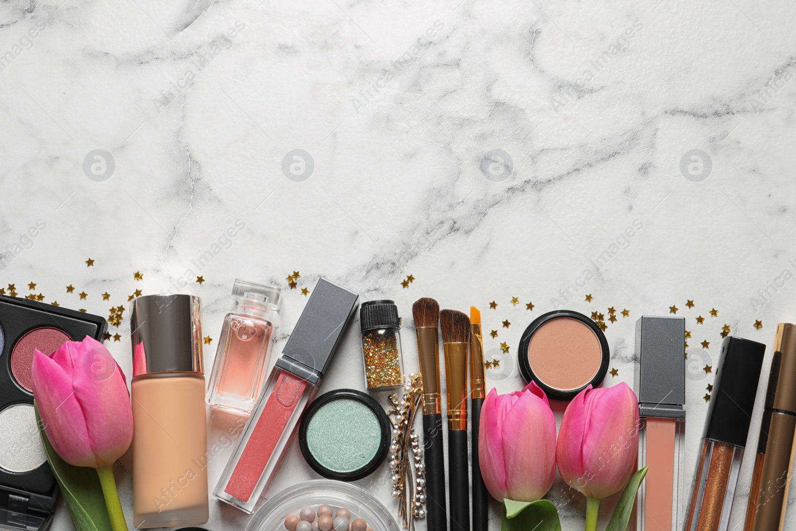 Photo of Makeup products and flowers on marble background, flat lay with space for text