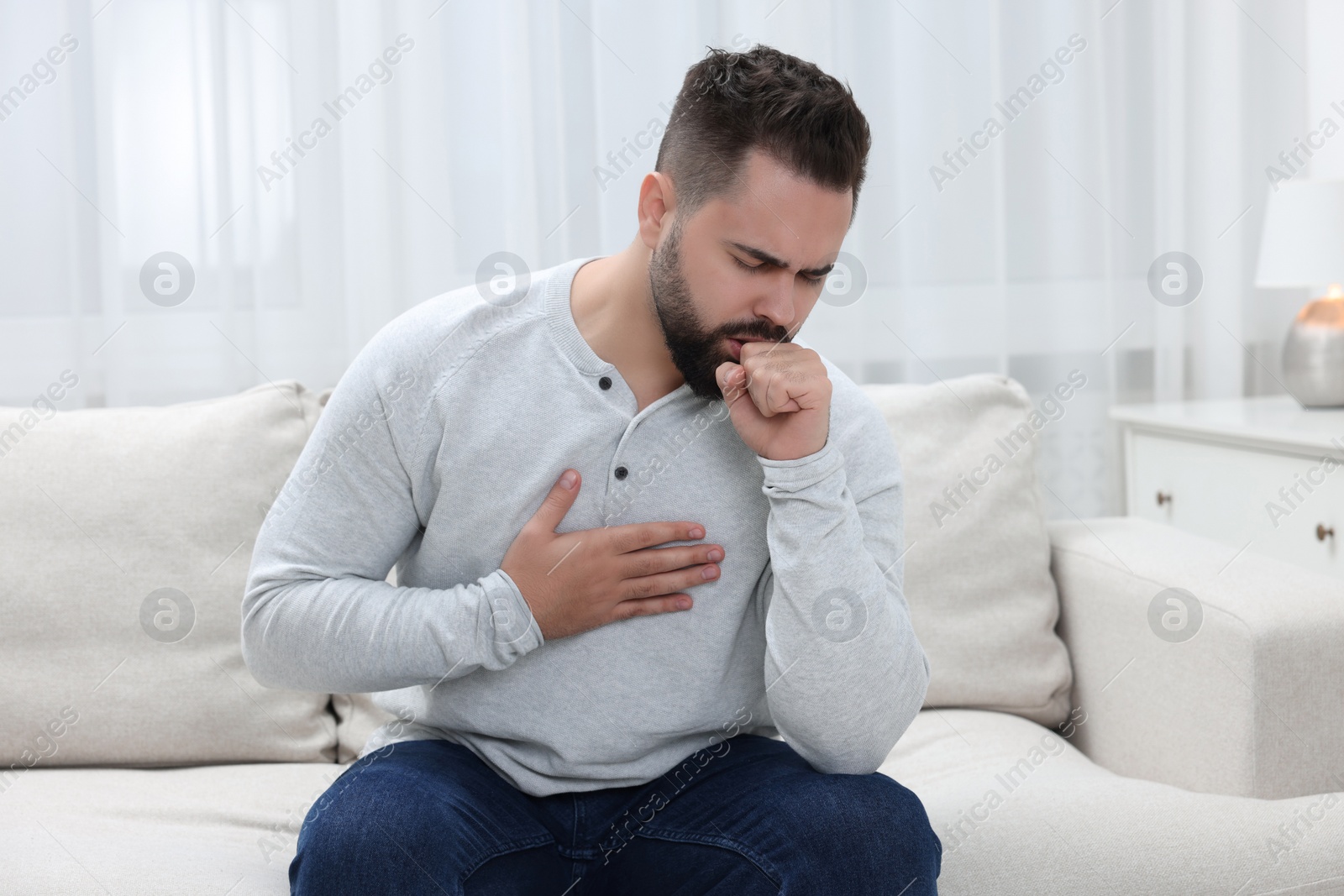 Photo of Sick man coughing at home. Cold symptoms